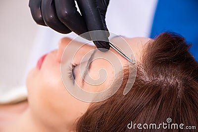 Young woman visiting male beautician in hair transplantation con Stock Photo
