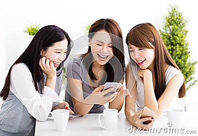 young women watching smart phone in living room Stock Photo