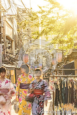 Young women in yukata in the the old-fashionned shopping street Yanaka Ginza famous as a spectacular spot for sunset. Yanaka Ginza Editorial Stock Photo