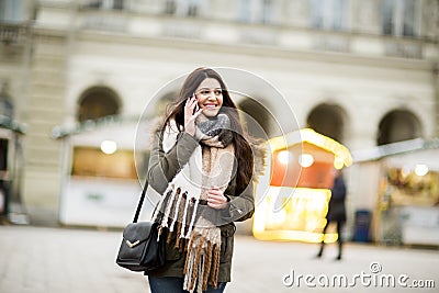 Young wonan walking down the street at cold winter day and using Stock Photo