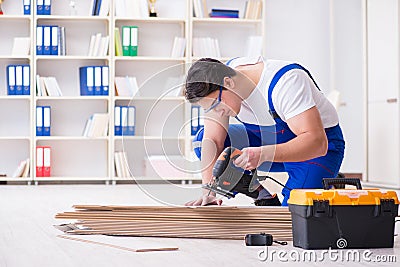 The young worker working on floor laminate tiles Stock Photo