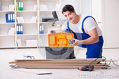 The young worker working on floor laminate tiles Stock Photo