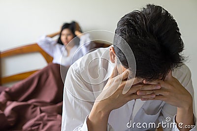 Young worried man on bed. Unhappy couple having problem in bedroom. Stock Photo