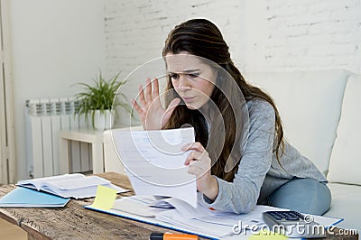 Young worried woman suffering stress doing domestic accounting paperwork bills Stock Photo