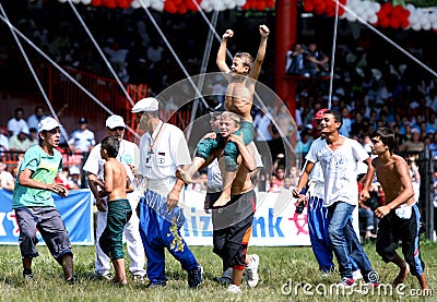 A young wrestler celebrates after winning his division at the Kirkpinar Turkish Oil Wrestling Festival in Edirne in Turkey. Editorial Stock Photo