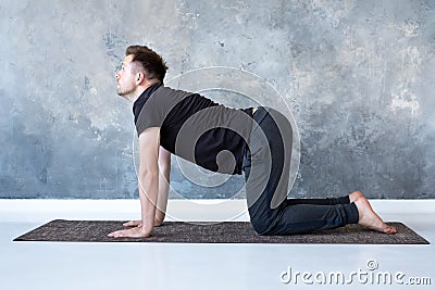 Young yogi men practices yoga asana bitilasana or cat cow pose Stock Photo