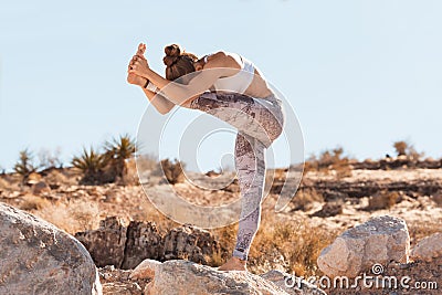 Young yogi woman practicing yoga in desert before a sunset Stock Photo