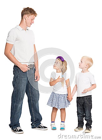 Younger brother and sister look at older brother Stock Photo