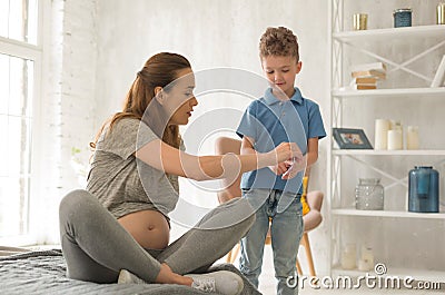 Pregnant mother talking to her younger son Stock Photo