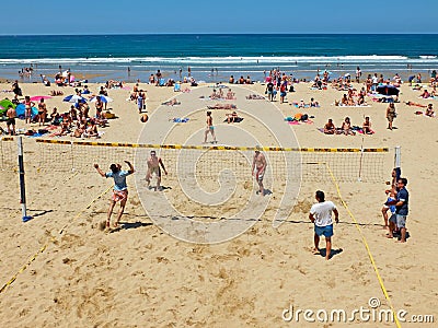 Youngs mens playing volleyball in Zurriola beach, San Sebastian. Spain. Editorial Stock Photo