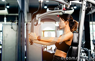 your arms with this arm exercise machine. healthy women exercise in fitness gym Stock Photo