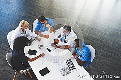 Your health is top of the meeting agenda. High angle shot of a team of doctors having a meeting in a hospital. Stock Photo