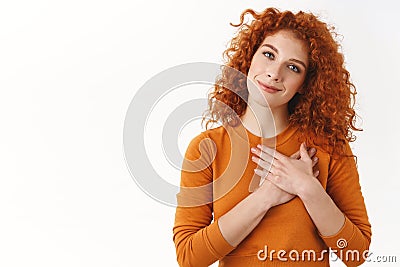 Your pleasant gift hit girls heart. Sensual gentle and tender curly-haired redhead woman hold hands on chest, tilt head Stock Photo