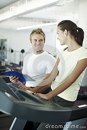 Your progress is pleasing. an attractive young woman working out with her personal trainer. Stock Photo