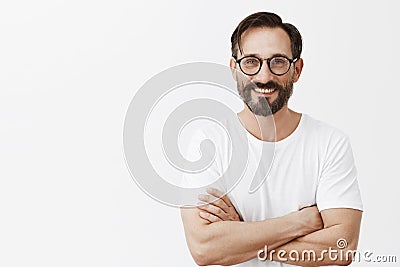 At your service. Charming carefree and confident european man with beard and dark hair in glasses and white t-shirt Stock Photo