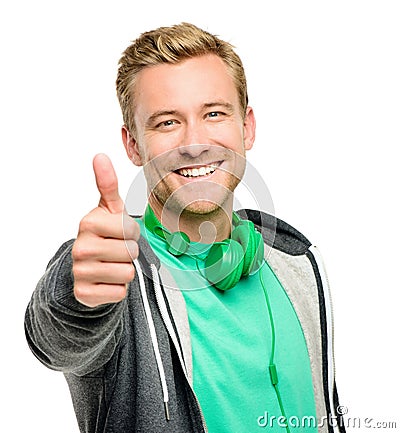 Youre doing great. a handsome young man standing alone in the studio and showing a thumbs up. Stock Photo