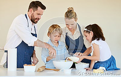 Youre doing a great job. a young family cooking together at home. Stock Photo