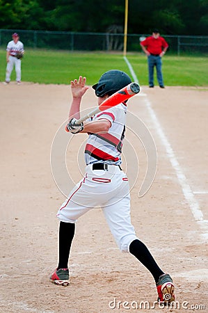 Youth baseball batter swinging bat. Stock Photo