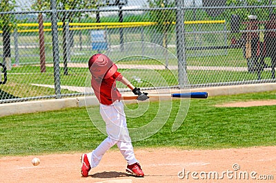 Young baseball player swinging bat Stock Photo