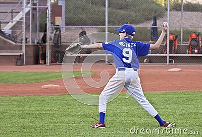 A Youth Baseball Player Throws the Ball Editorial Stock Photo