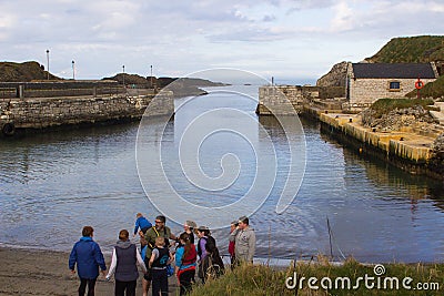 A youth group receives instructions from the group leader before taking part in water sports at the harbor in Ballintoy on the Nor Editorial Stock Photo