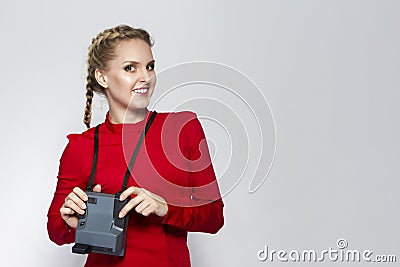 Youth Lifestyles. Posiitve Caucasian Blond Girl Posing With Old School instant Camera in Red Dress Stock Photo