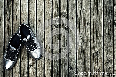 Youth women`s silver sneakers on the floor. Gym shoes Stock Photo