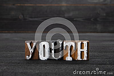 Youth. Word from wooden blocks on a dark textured background Stock Photo