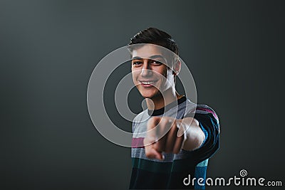 Cheerful youth extends hand, smiling warmly, inviting Stock Photo