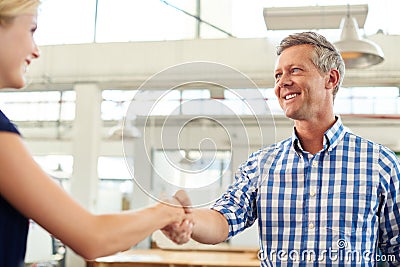 Youve been doing a great job. a businesspeople shaking hands in an office. Stock Photo