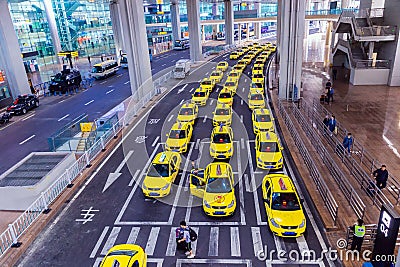 Group of yellow taxi cabs waiting arrival passengers in front of Airport Gate. Chongqing Jiangbei international airport in CHINA Editorial Stock Photo