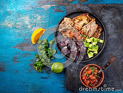 Yucatan Mexican Food Pork POC CHUC poc chuck. Pork marinaded in orange juice served with avocado, purple onion and rustic tomato Stock Photo
