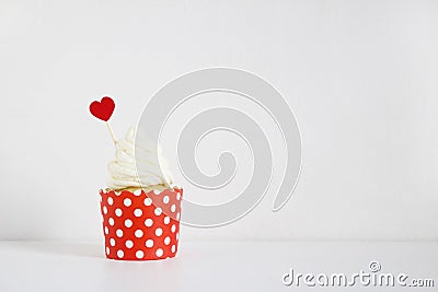 Yummy cupcake with red paper heart decoration on white table. Birthday, wedding or Valentine party food. Love concept. Stock Photo