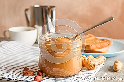 Yummy peanut butter breakfast on grey table against light brown background Stock Photo
