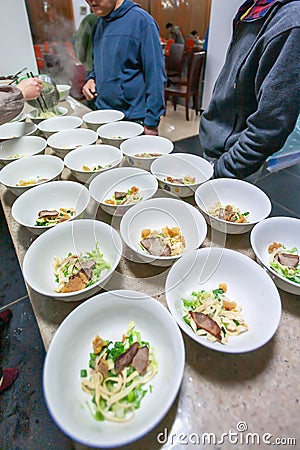 Yunnanese egg noodles with pork and vegetables in white bowls, local food in Yunnan, China Editorial Stock Photo