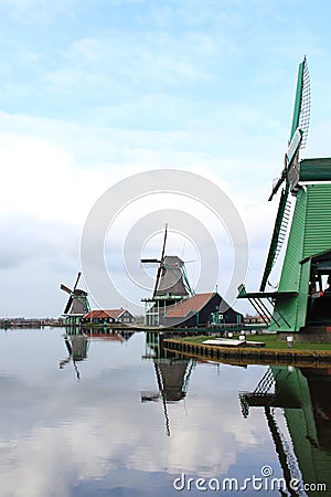 A CLASSIC WINDMILL REFLECTING AT THE CALM WATERS OF ZAANSE SCHANS Stock Photo