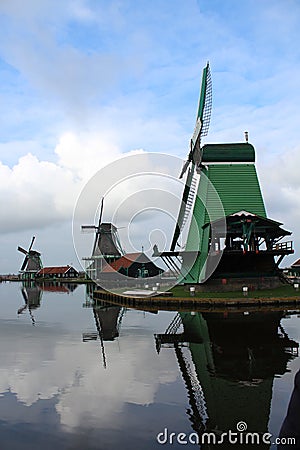 A CLASSIC WINDMILL REFLECTING AT THE CALM WATERS OF ZAANSE SCHANS Stock Photo