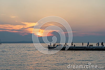 Zadar, Croatia - Aug 12, 2020: Sunset at Adriatic sea with tourists at pier Editorial Stock Photo