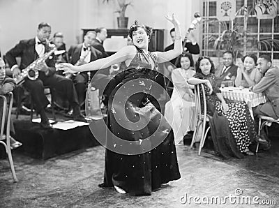 Zaftig woman performing a dance in front of a group of people in a restaurant Stock Photo