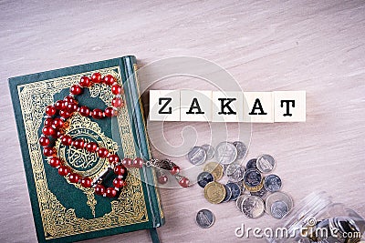 Zakat concept: Quran and tasbih with jar full of coins Stock Photo