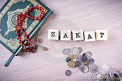 Zakat concept: Quran and tasbih with jar full of coins Stock Photo