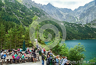 Zakopane, Poland - August 23, 2015: People eating (has snack) near Eye of the Sea lake. Poland. Editorial Stock Photo