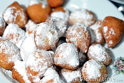 Zalabia covered with powdered sugar on a white plate, a type of middle eastern fried dough similar to that of a doughnut Stock Photo