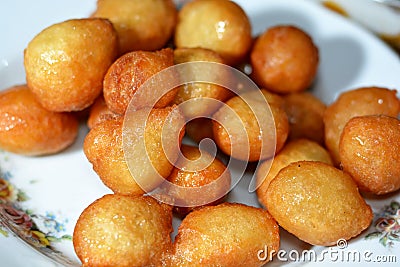 Zalabia on a white plate, a type of middle eastern fried dough similar to that of a doughnut, a tasty dessert Stock Photo