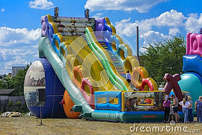 Zarechany, Ukraine - June 10, 2018. Children play on an inflatable carousel. Meeting of residents at the festival of the village Editorial Stock Photo