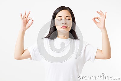 Zen sign. Calm asian girl in blank white t shirt isolated on template background. Copy space. Stock Photo
