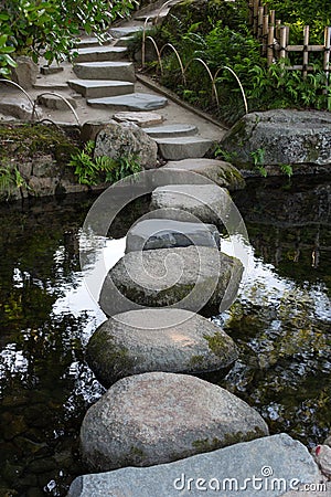 Zen stone path in a Japanese Garden across a tranquil pond in Ok Stock Photo