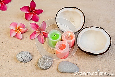 Zen tropical background with coconuts, plumeria flowers, rocks, and burning candles Stock Photo