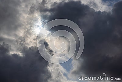 zenith pointed incoming storm cloudscape with heavy clouds and sun between them, full-frame real life photo Stock Photo