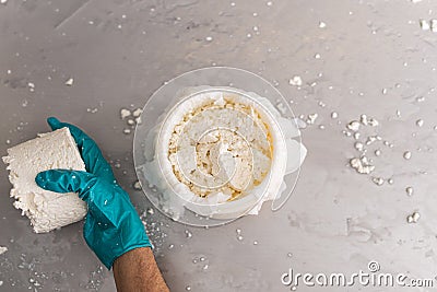 zenithal shot of an unrecognisable woman& x27;s hand at work in the process of creating fresh cheese. Stock Photo